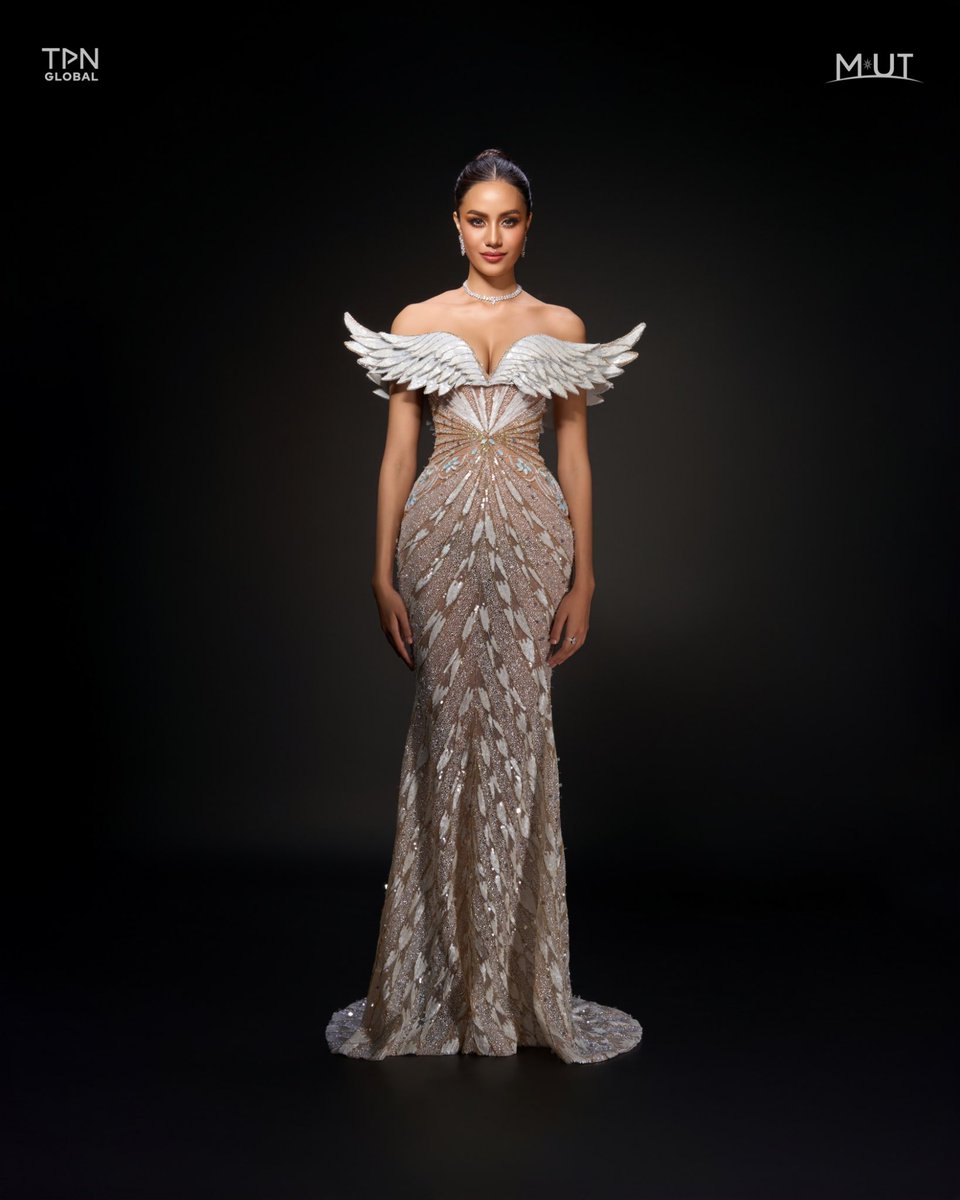 QUEEN’S WINGS OF TRIUMPH. 

Opal Suchata's gown for the Miss Universe 2024 stage is a stunning tribute to Thep Kinnaree, skillfully designed by Rian Fernandez with the opulence of gold and the purity of white. Crafted from luxurious micro sequin embroidery in shimmering gold and