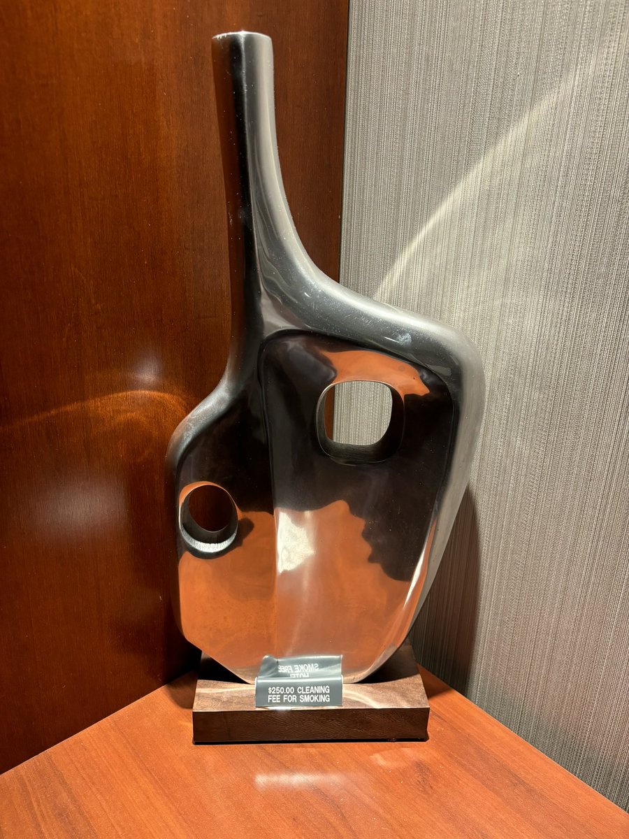 Interesting placement of this sign in a hotel room in Rockville. Is it connected to the hardware?  Is that art or a pipe?