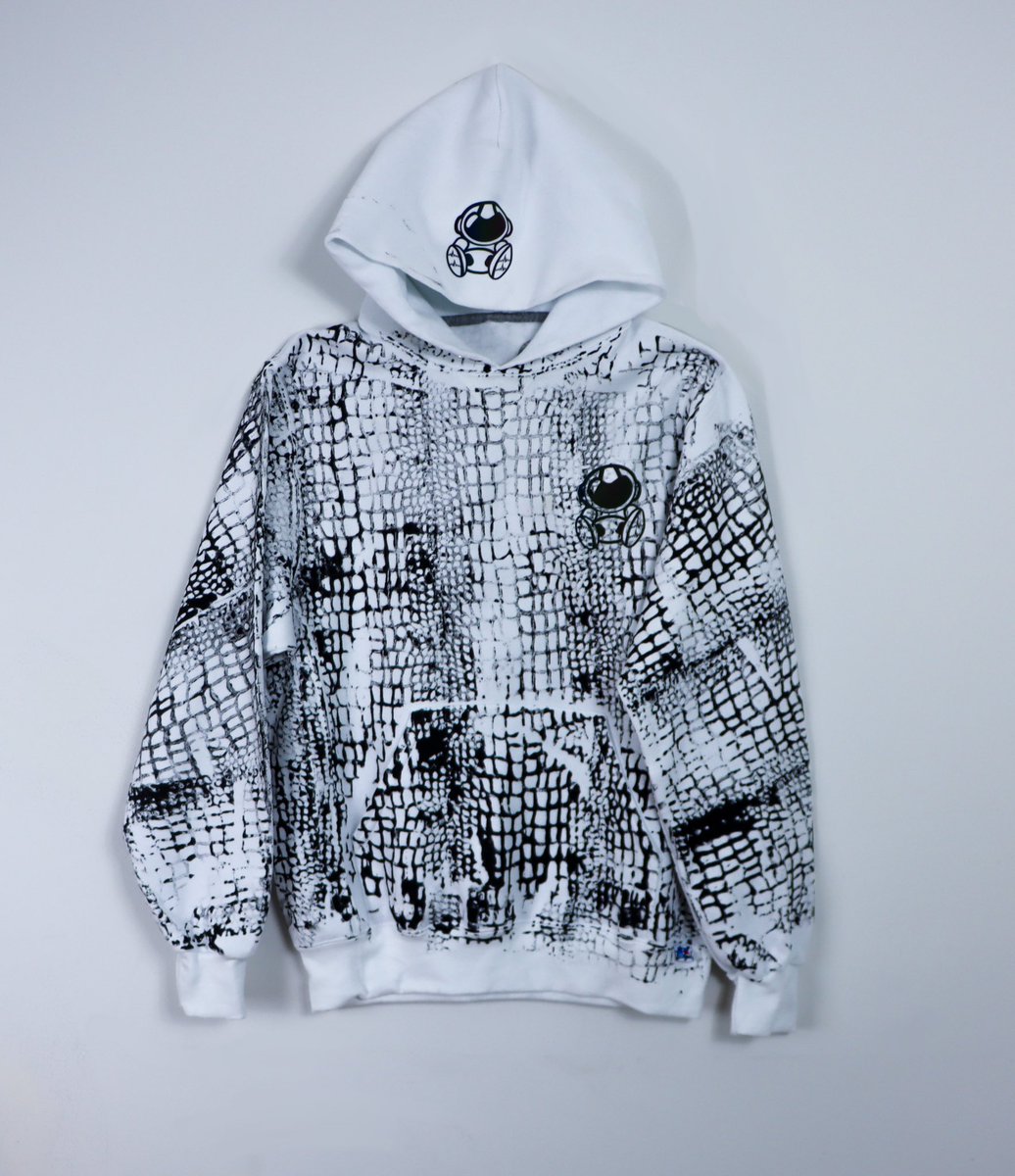 astroancient's tweet image. Introducing the 2025 Year of the Serpent Collection: the ultimate fusion of power, style, and mystique. This exclusive drop features a sleek white hoodie, adorned with a bold black snake print that embodies transformation and resilience.