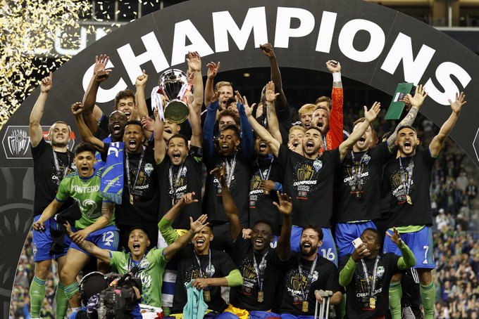 Seattle Sounders FC players celebrate with the Concacaf Champions League trophy.