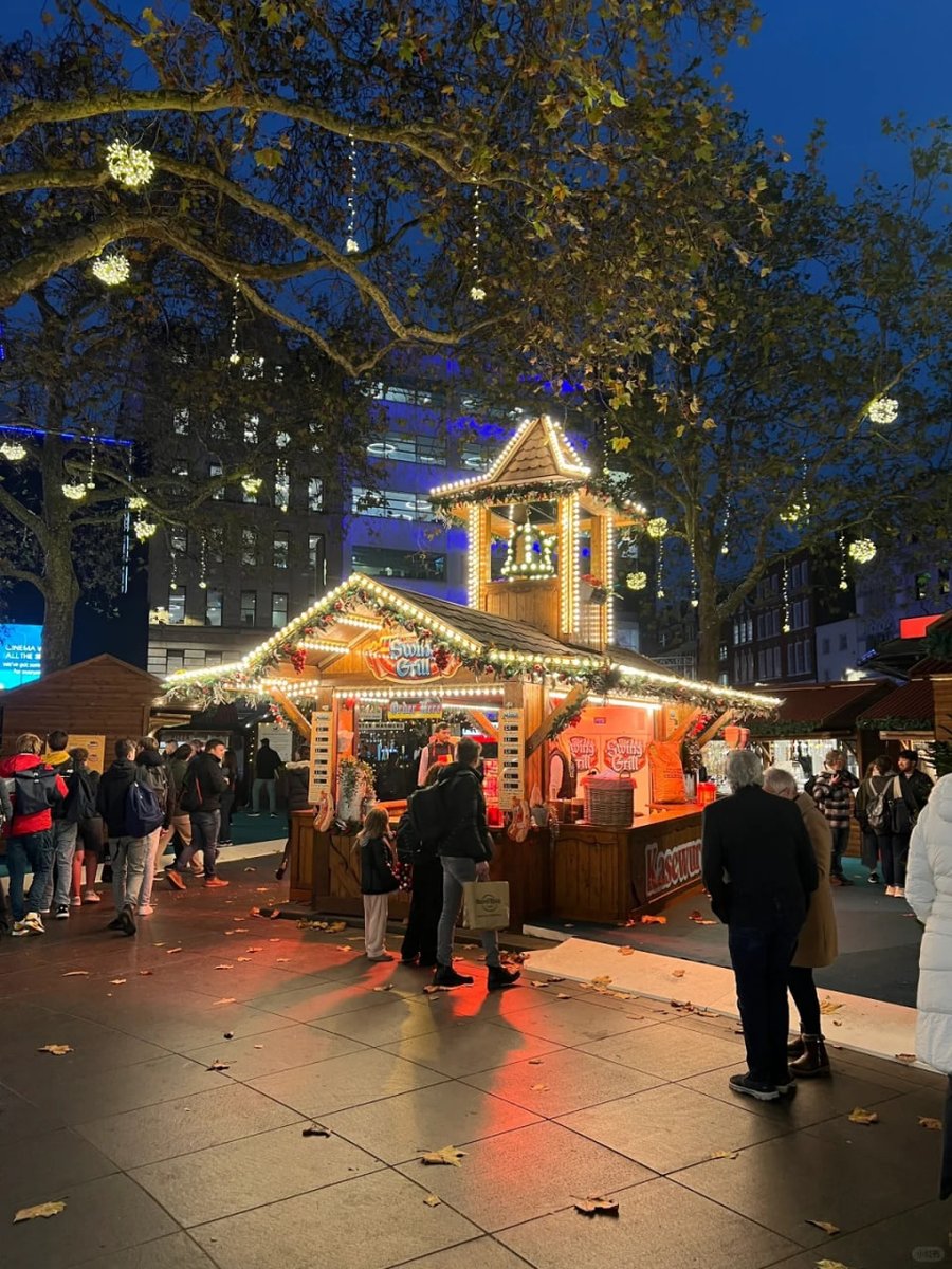 orientalli's tweet image. Crowds gather around a charming holiday stall adorned with garlands and lights, with people enjoying the lively and festive atmosphere.