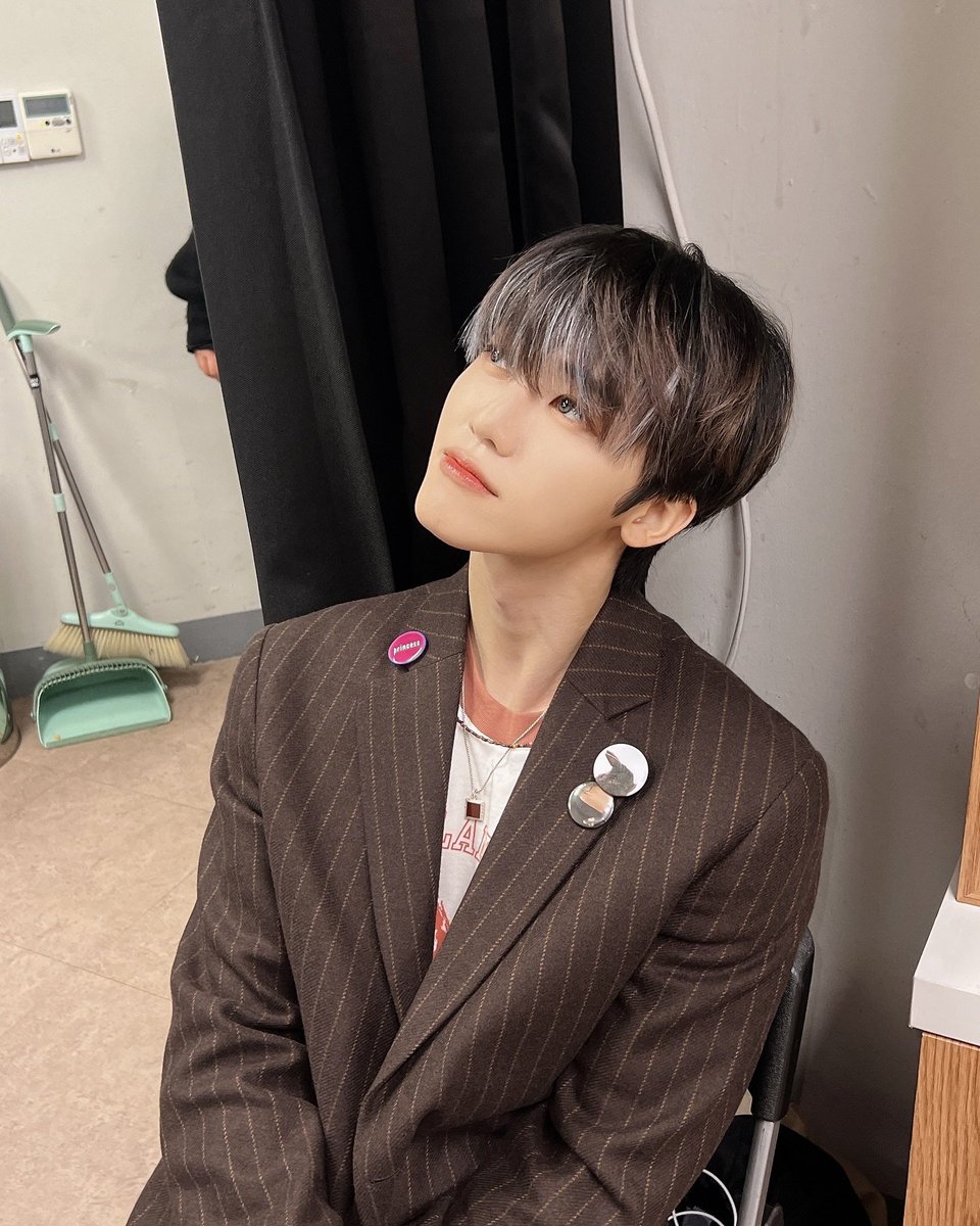 A calm vibe here. The head tilt says 'just chilling,' but the way the light catches the angle adds this soft, thoughtful mood. It’s a mix of elegance and nonchalance, framed perfectly by the dark curtain in the background.