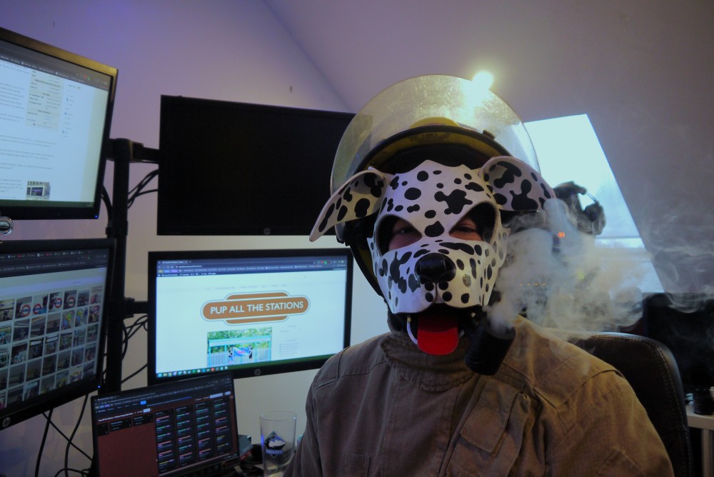 Not only is FirePup Spots good at posing with fire extinguishers, he's also helpful around the house.  Here we see him helping with the teardown of the studio for <a href="/TigerTailsRadio/">TigerTails Radio</a> but he's also helping keep the <a href="/PupTheStations/">PupAllTheStations</a> website updated.  Such a helpful FirePup.