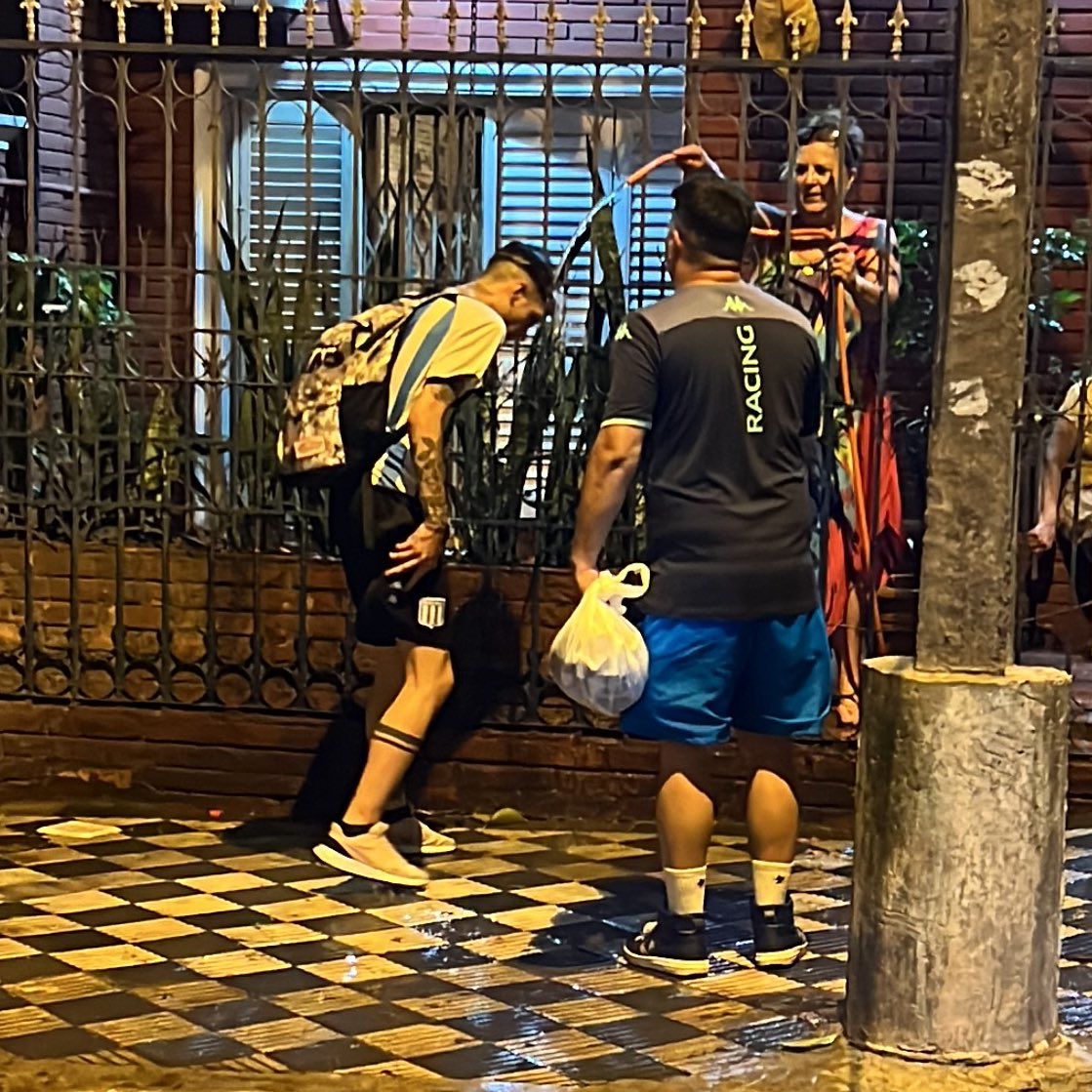 patomolina's tweet photo. Hay una señora divina que sacó la manguera por la reja para mojar a los hinchas de Racing que sufren el calor. Tipaza. Paraguay pueblo hermano y generoso. https://t.co/DyFQOC9BTd