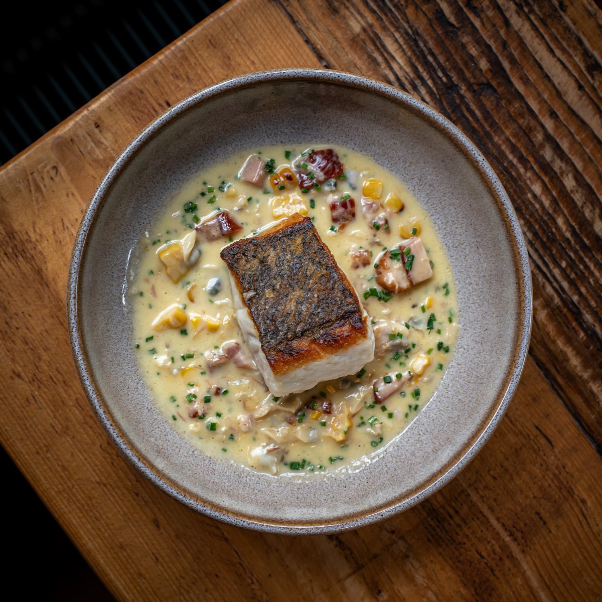 Our stonebass dish served with the trim from our smoked belly bacon dish, charred corn, clams and a pickle onion monster munch butter sauce