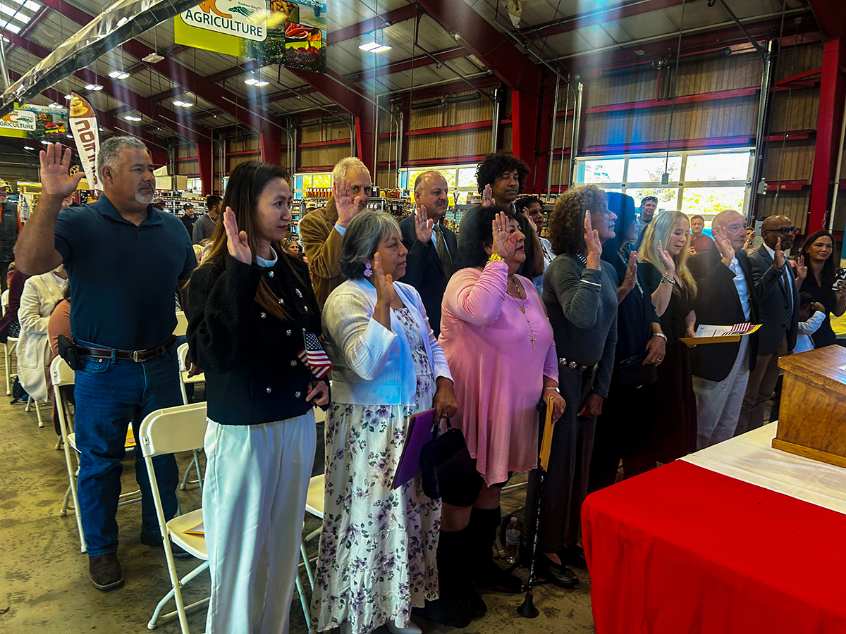 USCIS's tweet photo. This year we are thankful for these 18 #HurricaneHelene survivors who became #NewUSCitizens at the Asheville, N.C. farmer’s market. USCIS Charlotte staff went to the mountain city ravaged by the storm to facilitate their naturalization and administer the Oath of Allegiance. https://t.co/QgscftNMi1