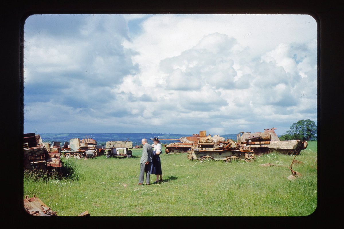 A beautiful Kodachrome slide I found of a couple standing in a field in France surrounded by rusted German tanks from World War II.