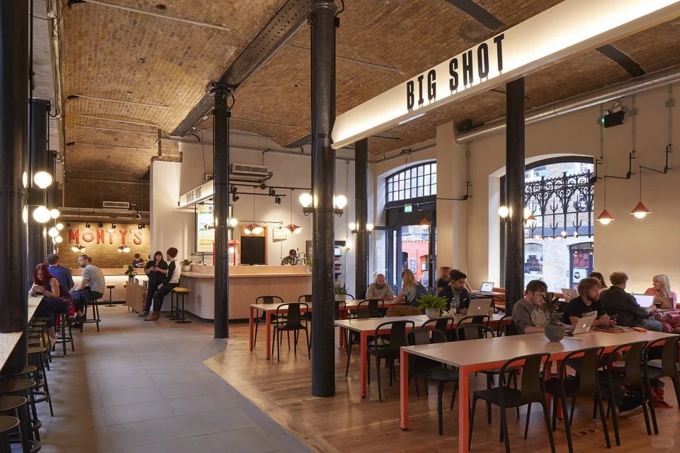 orientalli's tweet image. A bustling market area under an arched ceiling with stalls selling fresh produce and goods, adorned by a sign reading "Cucumber Alley
