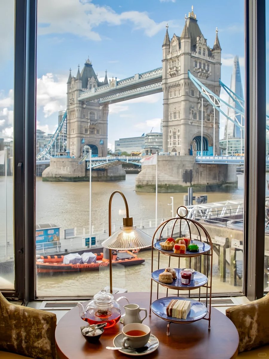 orientalli's tweet image. Afternoon tea set with a view of the iconic Tower Bridge in London.