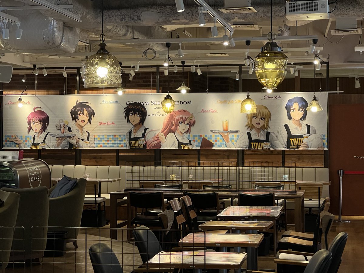 yoshi115t's tweet photo. 『機動戦士ガンダムSEED FREEDOM×TOWER RECORDS CAFE』
本日10:30にオープンしました。
ここ独特のルールもあるり、90分という限られた時間の中では堪能し切れない人もいるのでは無いかと心配。

画面の映像は撮影禁止です。
（これらの写真は一瞬の暗転時に撮影）

食事と会計(に付随したグッズ購入)は同時進行。
そして、自由に歩き回って撮影して良いのは会計が終わった人。
その会計は入店時の生理番号順です。
予約時に発行されたナンバーは席番号でしかないので、来店した順に生理番号が振られます。

各テーブルにはキャラ6人のイラストが2種ずつ使用されており全12種の絵柄があります。

なかなかのハードモードでした。

店内の詳細や、メニューの写真は夜にでもツイート出来ればと思っています。