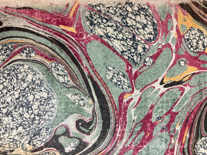 CHS 339 Marbled Endpapers 1: Marbled endpapers in swirls of black, green, reddish purple, and cross-hatched black and white splodges.