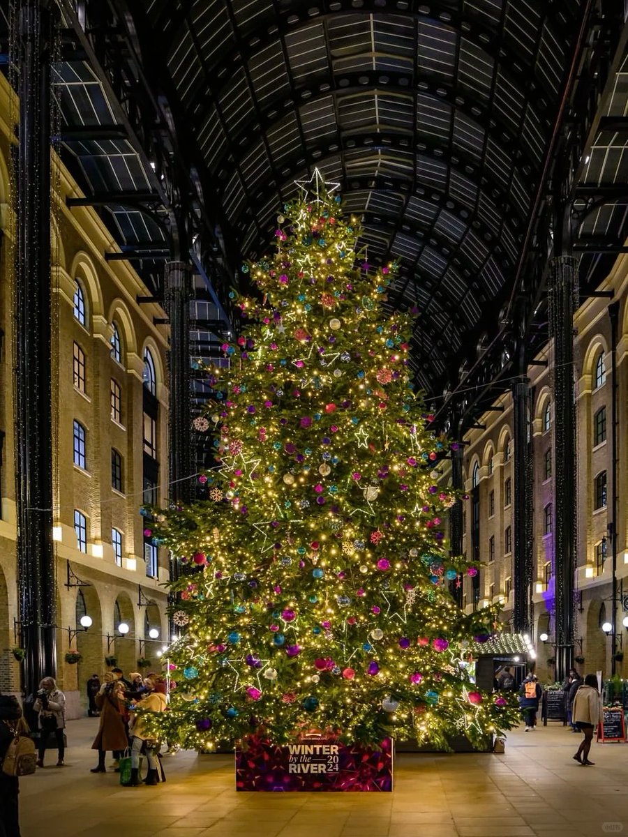 orientalli's tweet image. The illuminated Christmas tree, beautifully decorated with stars and ornaments, brightens up a busy indoor area.
