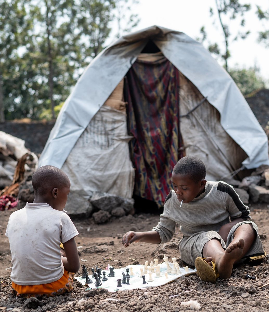 Displaced by conflict, two children play chess infront of their temporary shelter in the DRC 🇨🇩