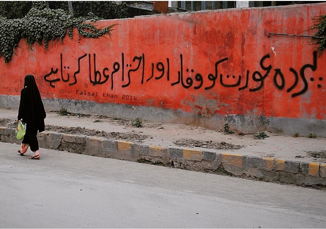 reclaimur_heart's tweet photo. A woman walks past a graffiti in old Srinagar Kashmir which reads ''Hijab makes a woman dignified and respectable'". https://t.co/Cu2hOooD8M