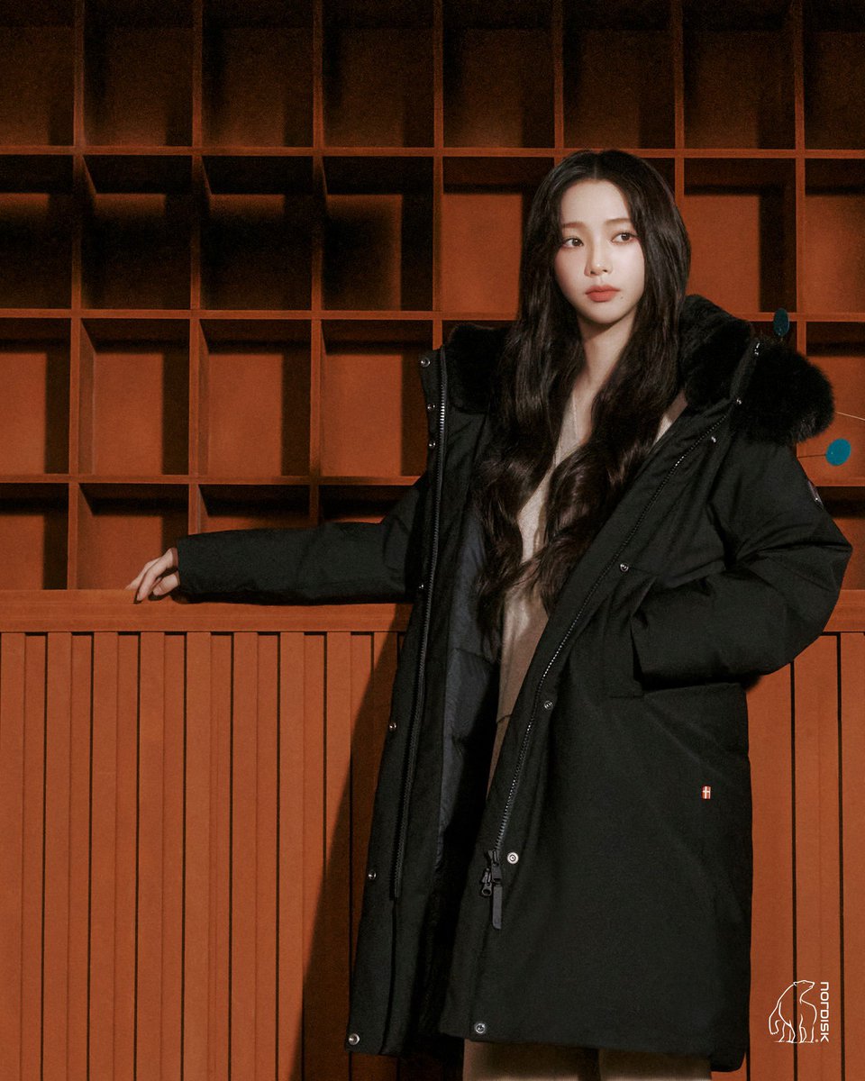 Wrapped in the soft embrace of this Nordisk coat, I feel the perfect balance of warmth and elegance. The fur-lined collar and rich wooden backdrop create a quiet confidence, where simplicity meets timeless style.