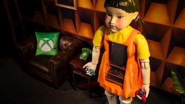 Image of the Squid Game Young Hee Gaming Cabinet next to a chair with a green Xbox pillow and side table with a green telephone