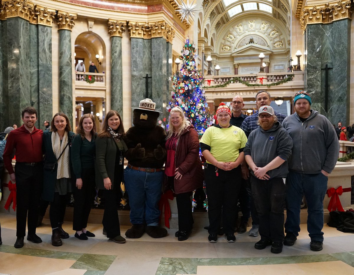 WisconsinDOA's tweet photo. The #Wisconsin State Capitol #HolidayTree has been officially lit, with a special guest in attendance—Smokey the Bear! The holiday season is here, and the tree is shining bright. Stop by to see the stunning display! https://t.co/YU6Shaefk5