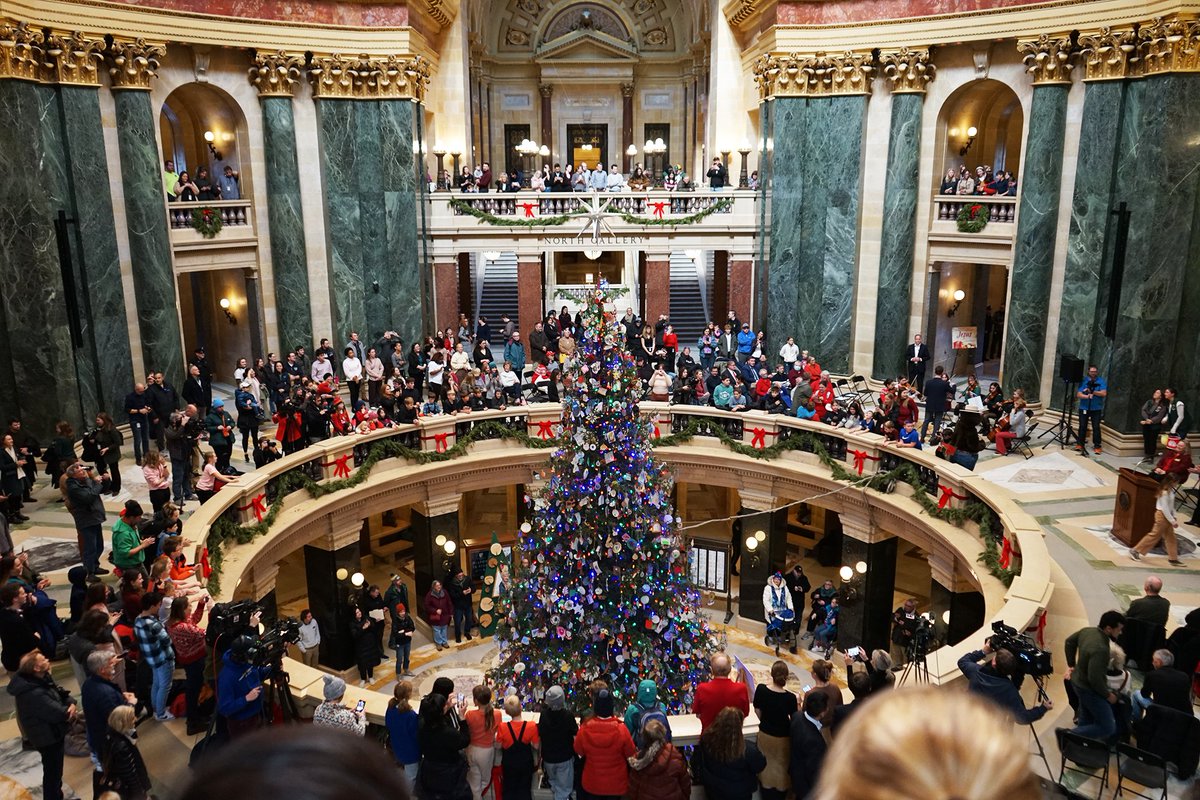 WisconsinDOA's tweet photo. The #Wisconsin State Capitol #HolidayTree has been officially lit, with a special guest in attendance—Smokey the Bear! The holiday season is here, and the tree is shining bright. Stop by to see the stunning display! https://t.co/YU6Shaefk5