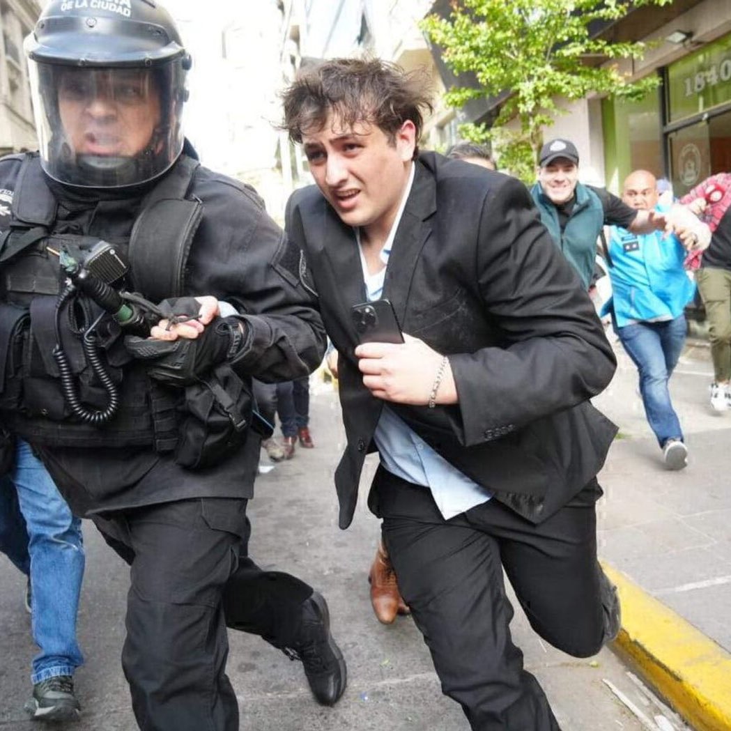 TugoNews's tweet photo. Primero se esconde atrás de un policía y ahora se esconde atrás DE UNA MUJER, el libertario es siempre y en todo momento un CAGÓN https://t.co/UgQ5rJgKE2