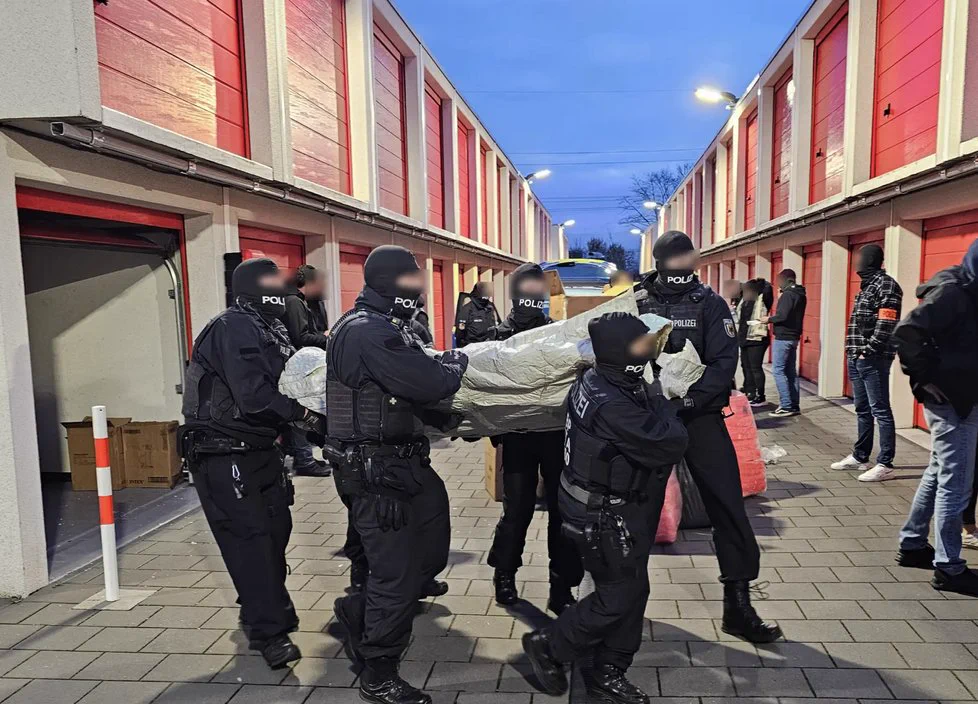 A photo of National Crime Agency officers carrying a large item from storage lockers.