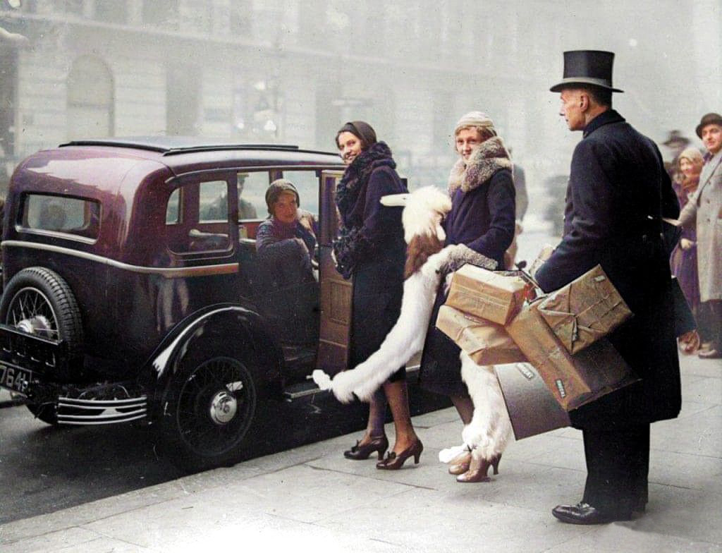 englandincolour's tweet photo. An attendant from Whiteley’s department store helps some ladies with their Christmas shopping in December 1930. #whiteleys #1930s #colourised https://t.co/yGWfEx4cOH