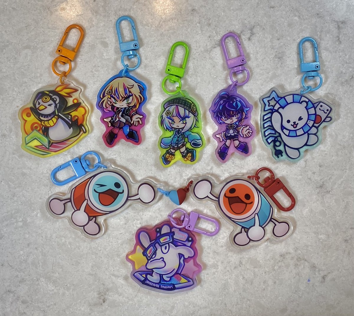 mittenmeat's tweet photo. my taiko no tatsujin restocks came in, so i can finally show off the lineup of rhythm game charms i’ll have at holiday matsuri! 
i did reorder the wacca ones to be a bit bigger, but i’m unsure if those will arrive in time ;-; either way, i’m so excited about these!!! https://t.co/7FAErPPq6Y