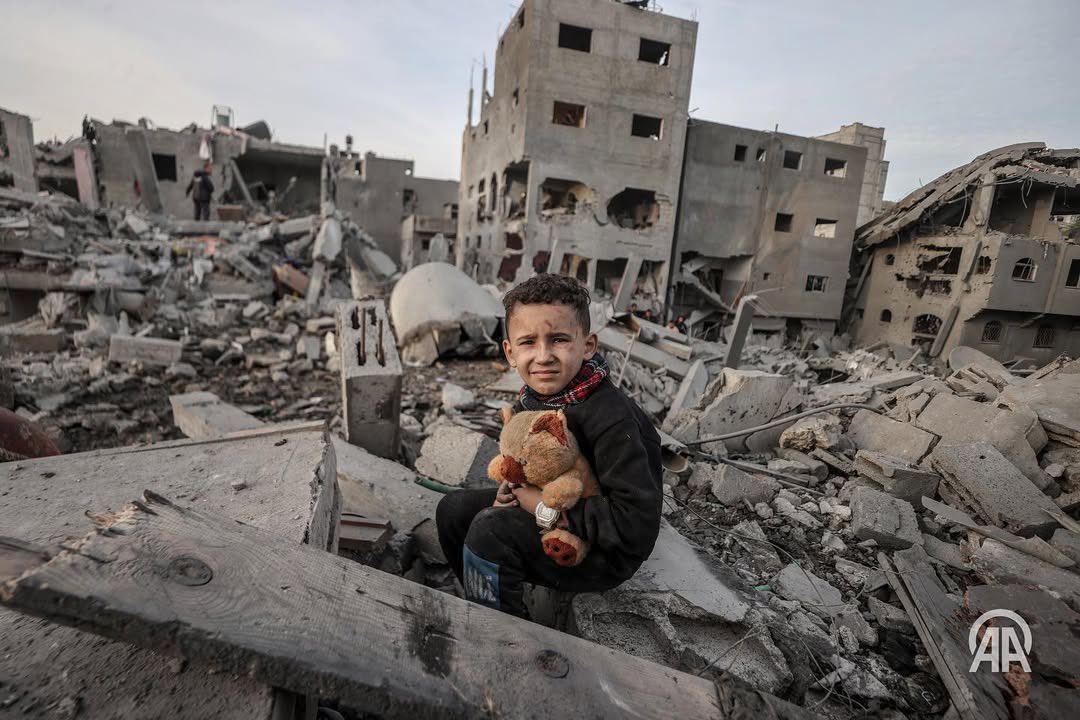 Palestinian child sits with his toy between the rubbles after an Israeli attack that destroyed Nuseirat Refugee Camp in Nuseirat, Gaza on December 7, 2024. The attack resulted in casualties, including deaths and injuries.