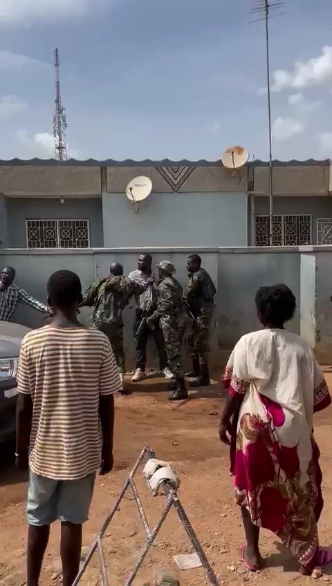 the Communication Officer tries to block the soldiers from approaching the polling station, leading one soldier to slap him