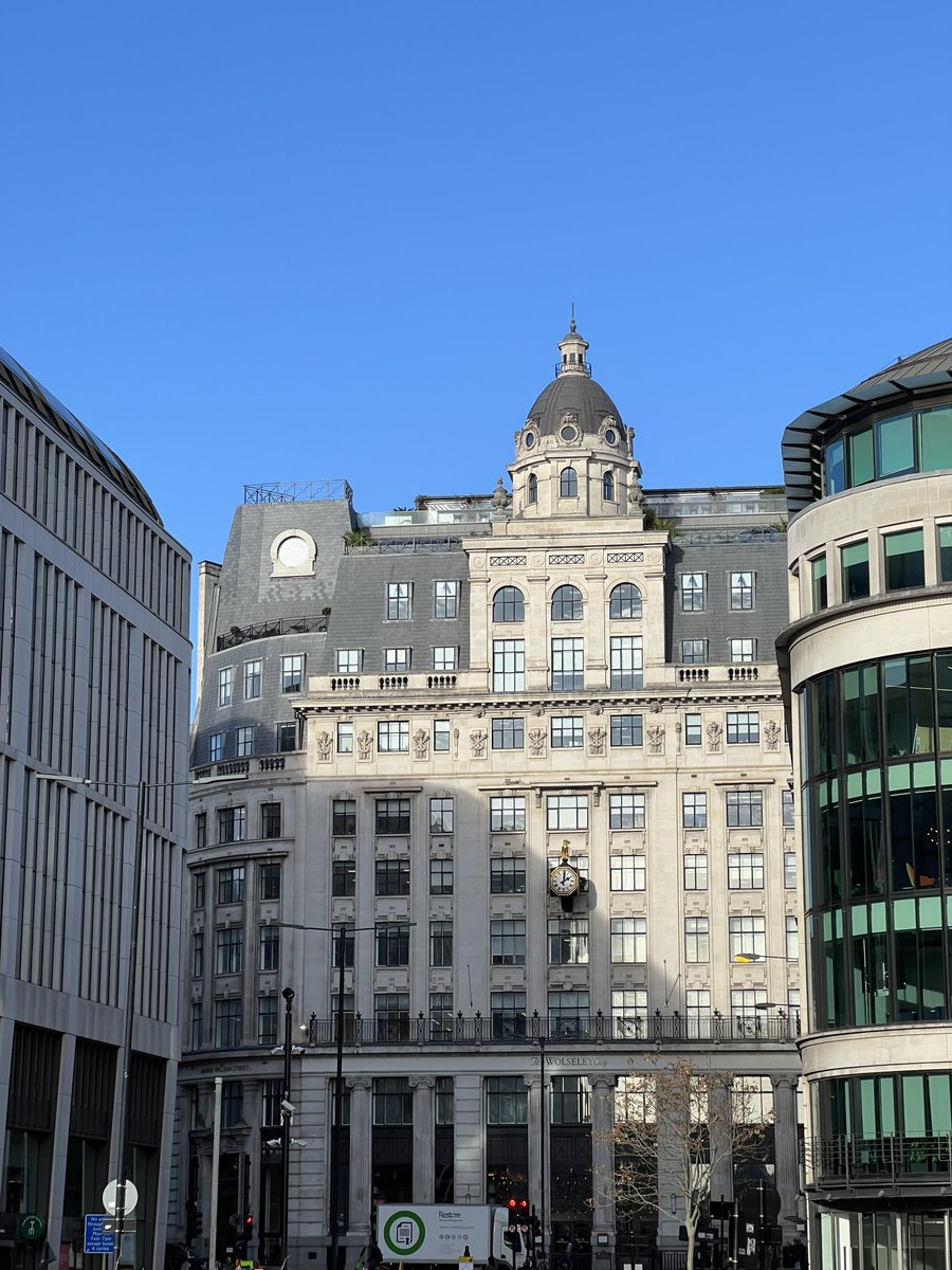 A majestic building with classic architecture against a bright blue sky🏙✨