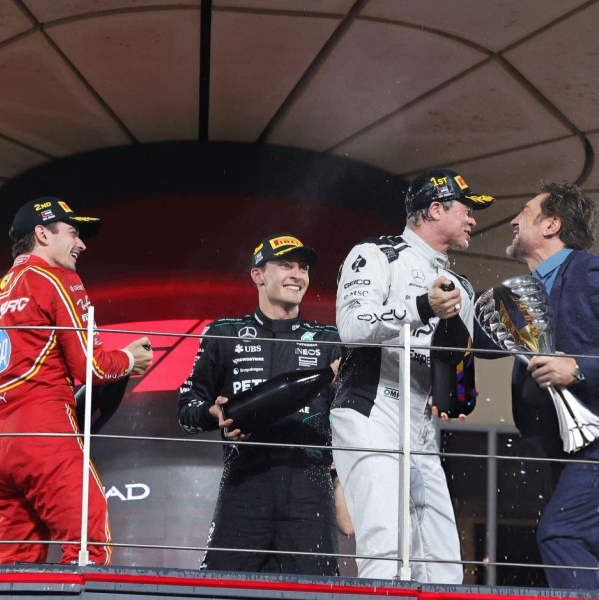 BOOKSCEDES's tweet photo. carlos and lewis saying their goodbyes in garage meanwhile these two are playing extras for the f1 movie 😭😭😭😭 https://t.co/imEAN2BbMD