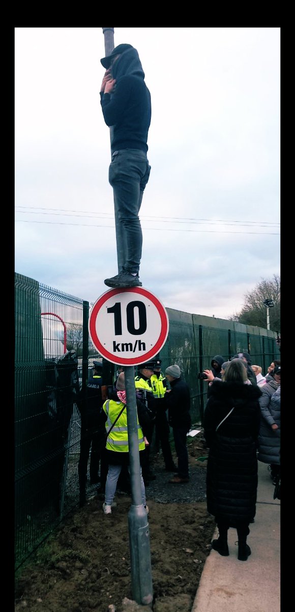 lil_doza's tweet photo. A far right protestor watching the Anti-Asylum Seeker protestors forcefully enter the centre in Athlone. 

Reports coming in -electricity has been switched off in the centre by Far right trespassers.The residents have no heating.