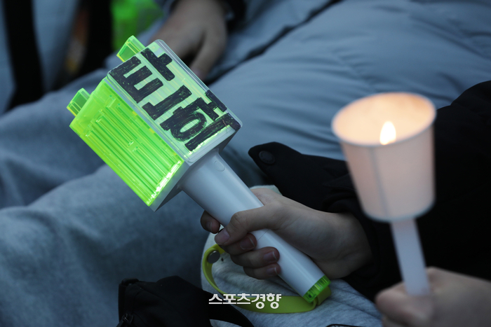 tang__kira's tweet photo. Lightstick idol K-pop jadi barang langka di situs jual beli barang bekas online.

Fenomena ini terjadi karena demo berskala besar untuk pemakzulan presiden, dengan lightstick idol sebagai ganti lilin atau candlestick.

Karena putaran kedua demo diperkirakan akan berlangsung akhir pekan ini, minat pembelian light stick melonjak di Korea. Stok lightstick, yang diproduksi sesuai dengan skala fandom mereka, udah pada habis. Karena pesanan buat produk barunya udah gak ada, semakin banyak orang yang mencoba beli produk palsu atau bekas di situs jual beli onlin