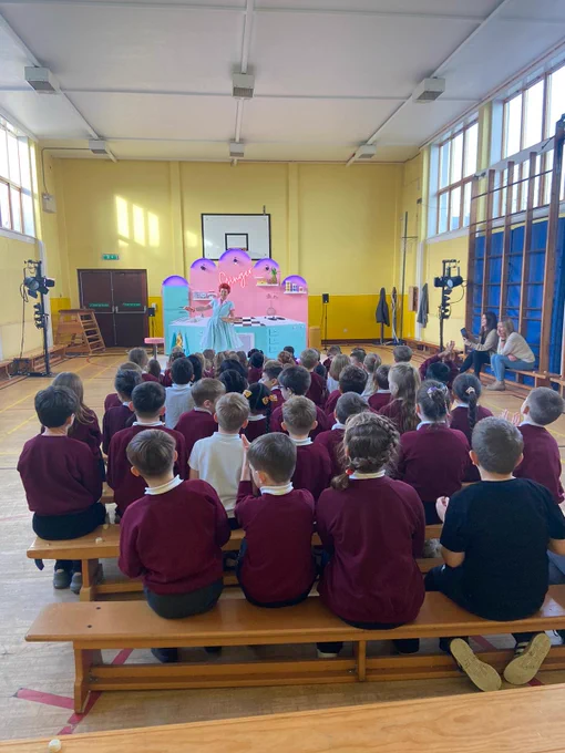 Ginger being performed in front of a group of school children. Set including a colourful kitchen.