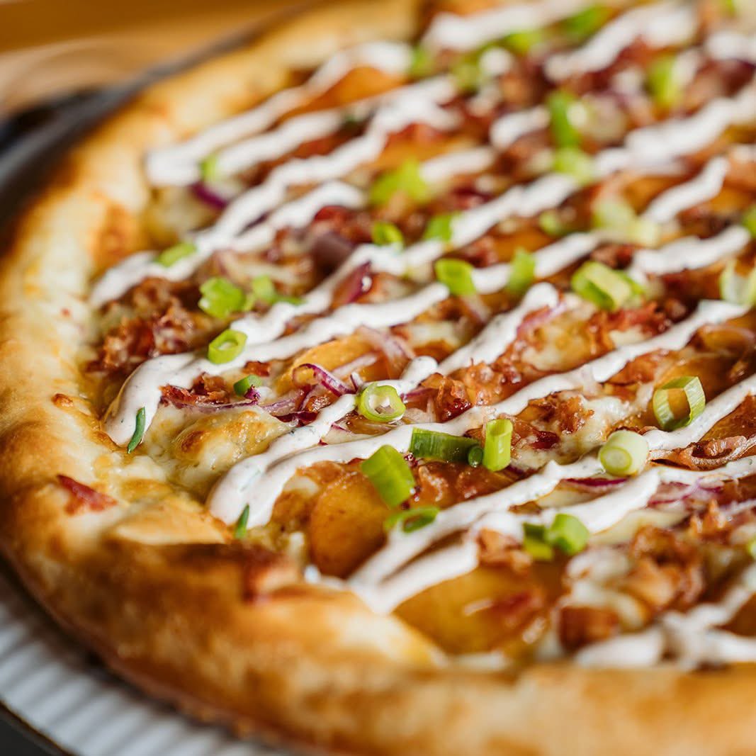 Yukon Cornelius is back! ⛏️ Order online at deweyspizza.com

You will strike it rich when you try this pie with olive oil, minced garlic, mozzarella, white cheddar, seasoned Yukon Gold Potatoes, red onion, bacon, and finished with green onions and lemon-chive sour cream.