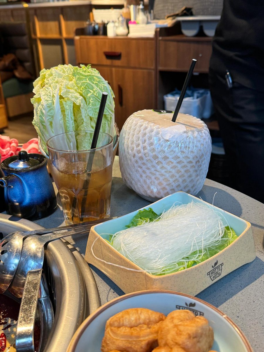 A vibrant hot pot setup with a variety of meats, tofu, vegetables, and a flavorful broth in the center🍽✨