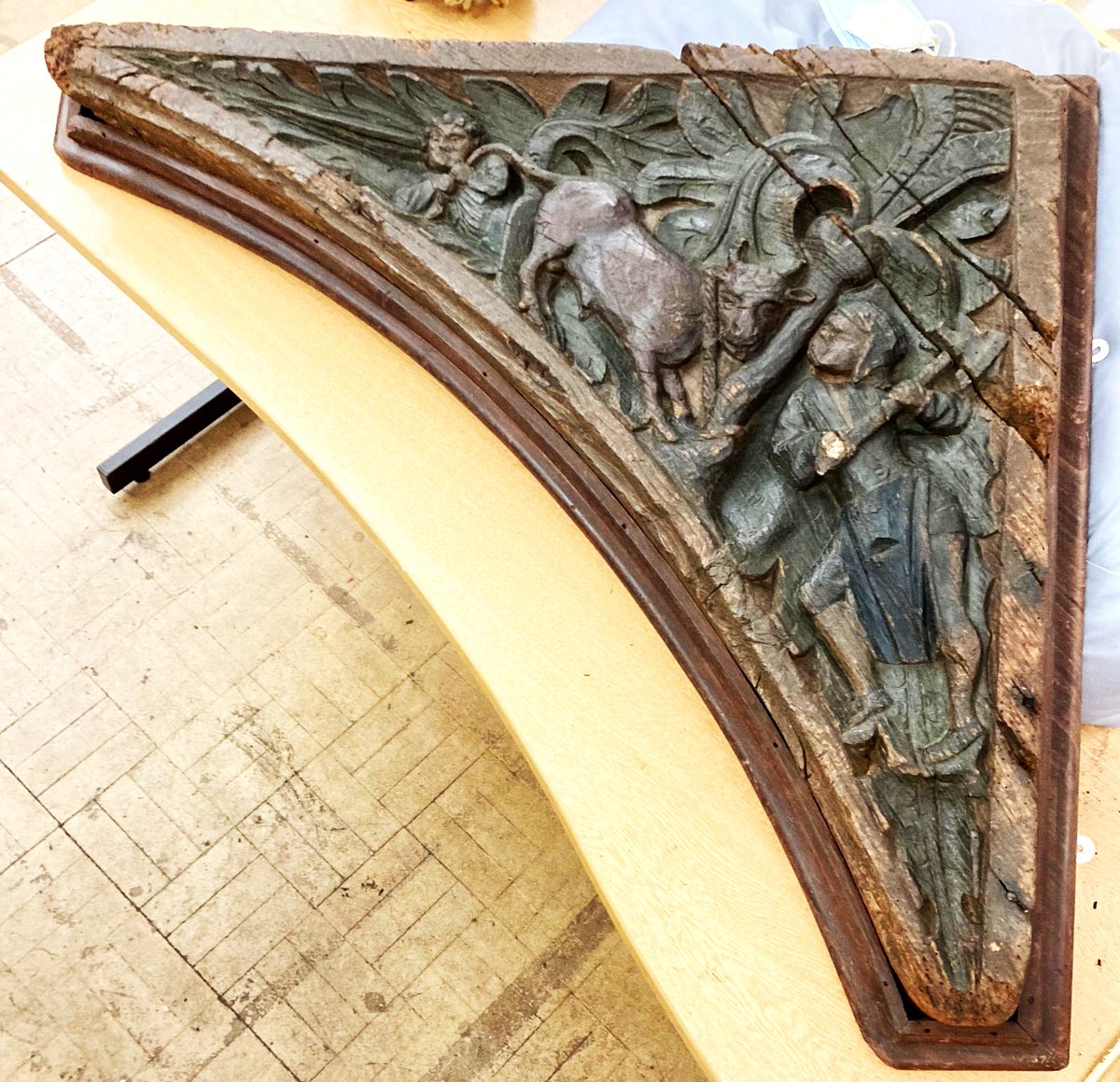 ConservationBob's tweet image. Ipswich Museum Conservation for redevelopment. Michael has been cleaning a medieval spandrel depicting 2 butchers pole axing a bull.  Vacuumed, brushed, wet cleaned and waxed to bring out the colour. The original paint can de seen after cleaning.