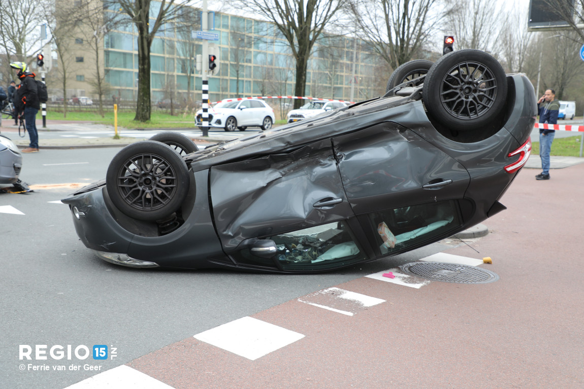 Auto over de kop op de Erasmusweg in Den Haag