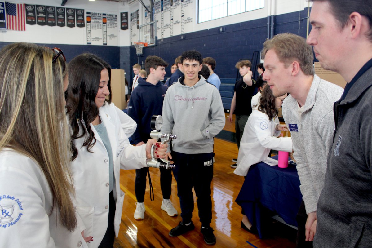 URI_Pharmacy's tweet photo. URI College of Pharmacy students teamed up with peers from Nutrition, PT, and Audiology to teach high schoolers about vaping, injury prevention, mental health, &amp; more! 🎉 From hearing tests to "Injury Prevention Jenga," they made health education fun &amp; impactful! #URxI💙 https://t.co/uEfNtdpOiG