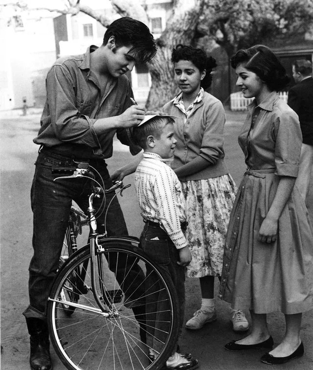 Elvis Presley signing autographs for fans in California in the 1950s.