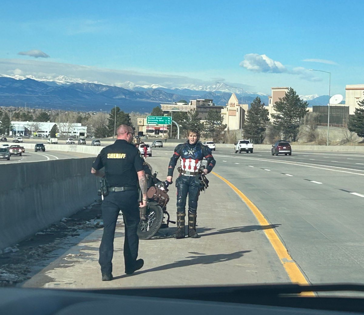 dcsheriff's tweet photo. Just another day in Douglas County. #DCSO Deputy Zepeski helping #CaptainAmerica when his motorbike broke down. We are here to serve. 👮  🦸‍♂️ https://t.co/dRtoYvEzfu