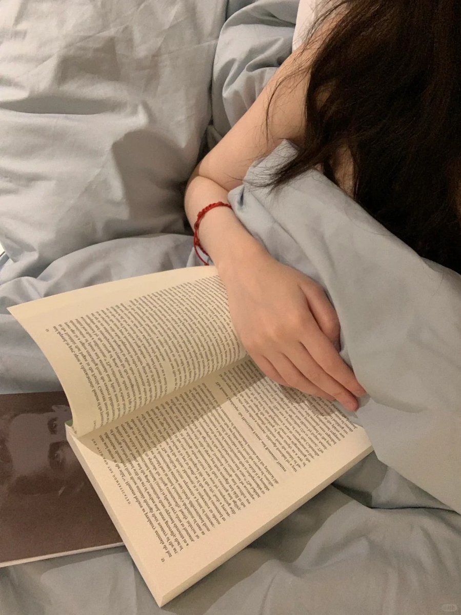 Curling up with a good book on a cozy bed. 📖✨