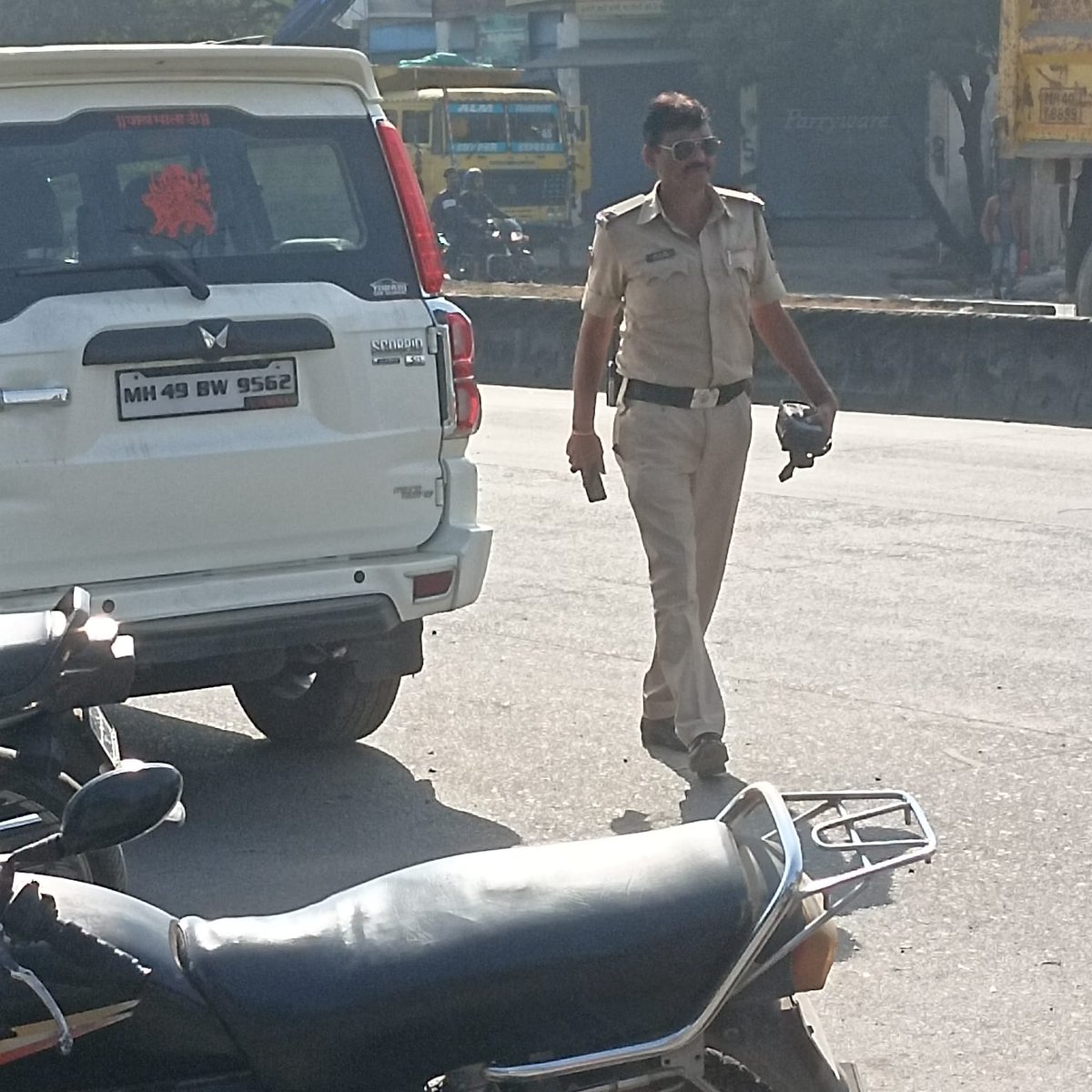 Gauravmm's tweet photo. This policeman is stopping vehicles &amp; clicking photos of vehicles but it can be clearly seen that he is having a challan machine in his hand. Why isn't he issuing the challan on the spot? Why issue challan online after letting the vehicle go?  @trafficngp @nagpurcp @archit_IPS https://t.co/X2HK8PlDw3