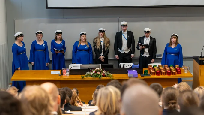 Turun yliopiston kuoron tuplakvartetti lauloi salin edessä kappaleen Koulutie / Double quartet of Turku University Choir sang in front of the audience at the lecture hall