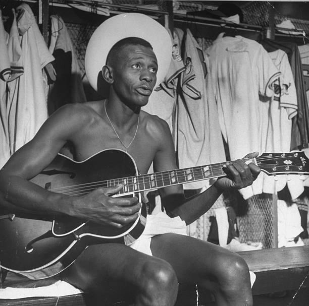 BBGreatMoments's tweet photo. Satchel Paige sporting a straw hat &amp; towel, while strumming guitar in the Cleveland Indians dressing room, 1948. https://t.co/FrDA7W0IWw