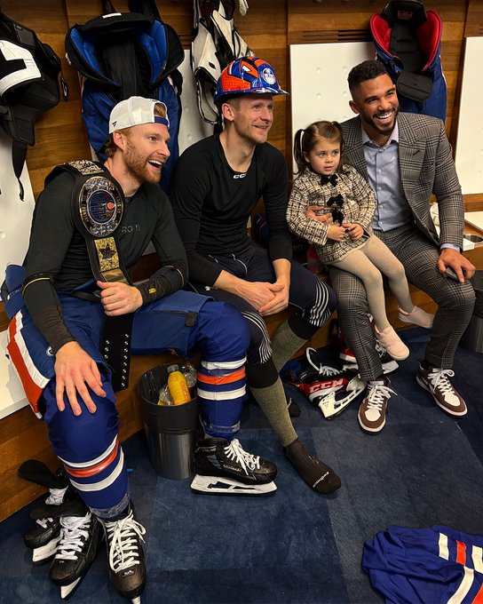 Connor Brown poses with the championship belt, Corey Perry wears the hard hat and the pair are joined by Evander Kane & his daughter for a post-game photo in the Oilers locker room 