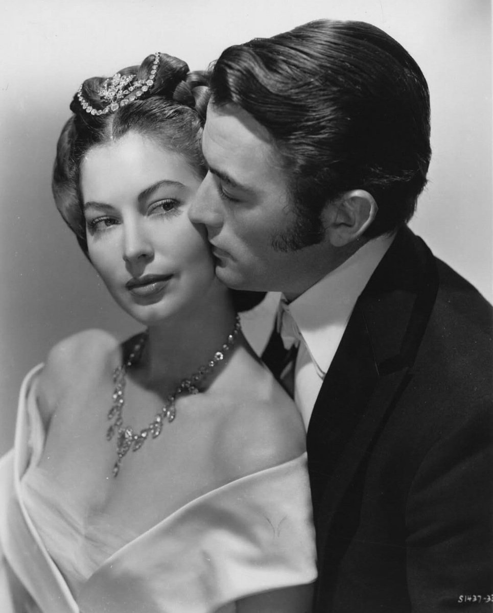 JuanmadelaPoza's tweet photo. En #ElGranPecador (#TheGreatSinner, 1949), de #RobertSiodmak, una arrebatadora #AvaGardner comparte pantalla por primera vez con otra de las grandes estrellas del momento: #GregoryPeck. Después volverían a hacerlo en #LasNievesDelKilimanjaro (#TheSnowsOfKilimanjaro, 1952), de #HenryKing, y #LaHoraFinal (#OnTheBeach, 1959), de #StanleyKramer, un notable drama postapocalíptico. «El gran pecador» termina siendo una adaptación demasiado discreta (aunque tiene algunos momentos notables) de una historia de #LadislasFodor y #RenéFüelöepMiller que, a su vez, adapta la novela del escritor ruso #FiódorDostoiesvki, #ElJugador. El guion corrió a cargo de dos grandes nombres, #LadislasFodor y #ChristopherIsherwood. Narra la historia de un joven escritor, Fedya (diminutivo de Fyodor), que de camino en tren hacia París se encuentra con una mujer hermosa, Pauline Ostrovsky (Ava Gardner), que le hace cambiar de idea para bajarse en Wiesbaden donde todos van a jugar al casino. Mientras investiga para escribir sobre el juego y los jugadores, acaba convirtiéndose él mismo en un jugador compulsivo. «El gran pecador» es un filme extraño que fracasó estrepitosamente en taquilla en el momento de su estreno y que, pese a tener un reparto espectacular por Gregory Peck, Ava Gardner, #MelvynDouglas, #WalterHuston, #AgnesMoorehead, #EthelBarrymore, #FrankMorgan y #ErnöVerebes, y una historia de fondo bastante interesante, la trama contiene muchos desórdenes narrativos, algunos de ellos muy importantes. Nunca acaba de unir un discurso del todo razonable y el filme fracasó estrepitosamente en el momento de su estreno. Además, introduce elementos de la propia vida de Fiódor Dostoiesvki y de otra de sus novelas más famosas: #CrimenYCastigo. Con un material tan interesante en sus manos, las presiones comerciales de #MetroGoldwynMayer y algunos cambios significativos en el montaje acabaron perjudicando el resultado final de la cinta. La primera versión del montaje duraba más de tres horas que se cortaron hasta los 110 minutos finales. Estos cortes se notan principalmente en las transformaciones súbitas que sufren los personajes principales, Fedja (Gregory Peck) y Pauline Ostrovsky (Ava Gardner). El primero es un escritor incrédulo y con cierto aire de superioridad que estudia las reacciones de los jugadores cuando se enfrentan a la ruleta del casino para escribir su nuevo libro. La metamorfosis que le hace convertirse en un jugador compulsivo resulta demasiado apresurada y fortuita para hacerla del todo verosímil, al igual que su posterior aceptación de ser un adicto y la urgente necesidad de redención. También ocurre algo similar con Pauline, una aristócrata rusa que se presenta como una mujer poderosa y de fuertes convicciones, para convertirse en la segunda mitad de la película, sin apenas darnos cuenta, en una persona sin capacidad de decisión propia que vive bajo la voluntad de su padre y del amor tan apasionado que siente por Fedja. La oscuridad y pesimismo inherentes a la historia no debieron convencer demasiado a los peces gordos de la Metro-Goldwyn-Mayer que consideraron necesario incrementar el peso del romance entre Fedja y Pauline, para lo que se contrató al director #MervynLeRoy (no acreditado) para suavizar el estilo más tosco de Robert Siodmak, que se negó a hacer esos cambios. La historia de amor dulcifica en exceso una trama que requería de una oscuridad tenebrosa para adentrarse en el infierno de las adicciones y la autodestrucción, solo hace falta contemplar ese final feliz forzado que resta de crudeza el mensaje pesimista que quería dar la película. «El gran pecador» es una película irregular que puede recuperarse como rareza y que tiene su mejor baza en una interpretación intensa de Gregory Peck, mejor cuanto más pasado de revoluciones está, junto a la seductora presencia de una Ava Gardner que aquí está desaprovechada tras una presentación prometedora y que fue escogida para sustituir a #LanaTurner que estaba de luna de miel por Europa.