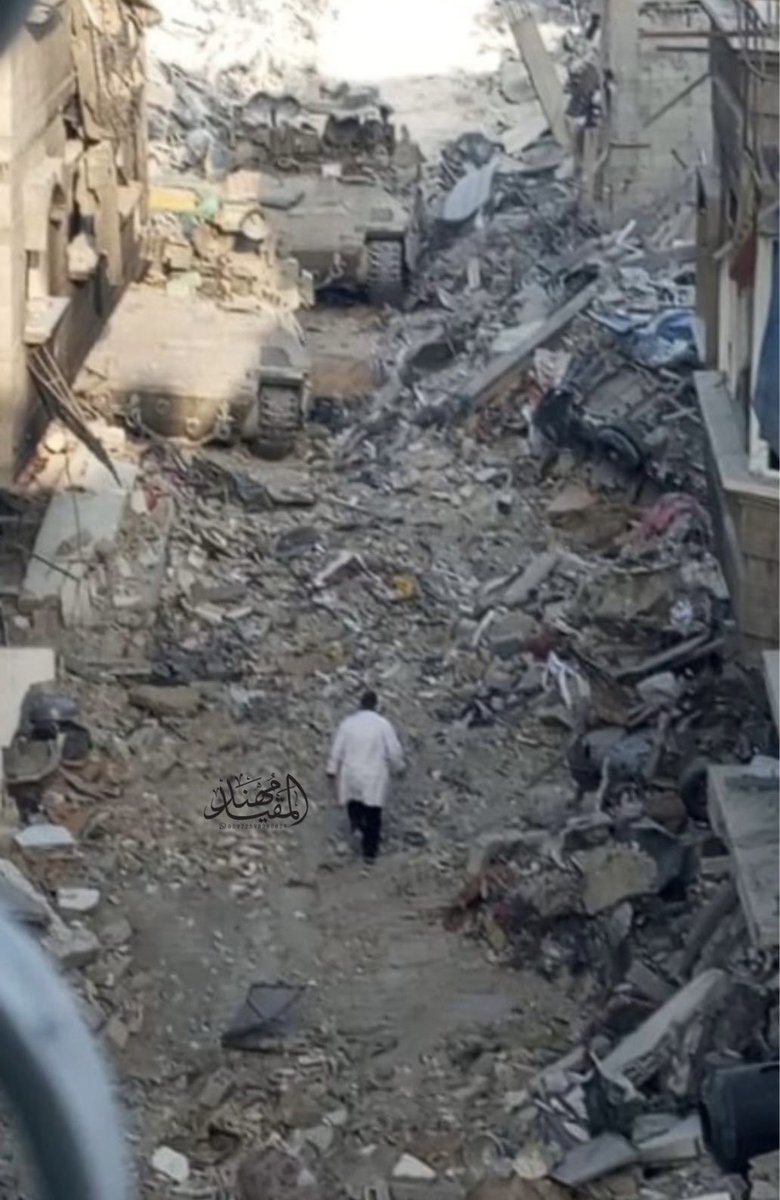 this is an incredibly powerful image

dr hossam abu safiya, director of kamal adwan hospital in Gaza, is seen facing an Israeli tank storming the hospital before he was then taken by Israeli soldiers