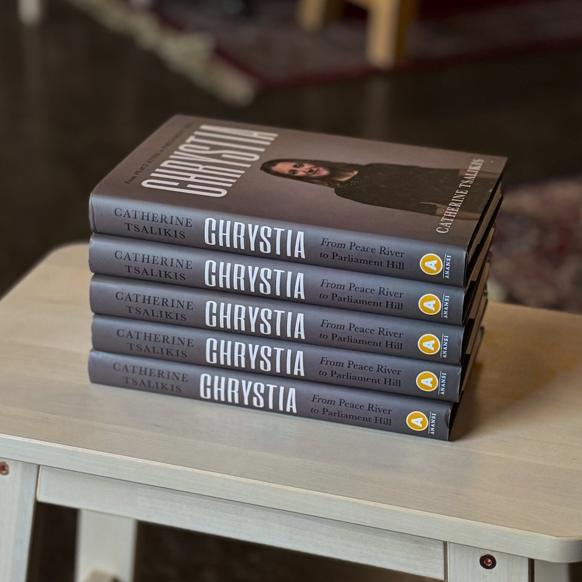 A photograph of a stack of copies of Chrystia on a wooden table.
