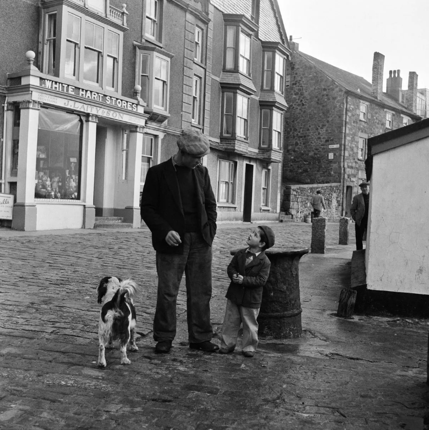 alton_benes's tweet photo. Returning after a week's fishing in the stormy Irish sea, fisherman Stanley Beazley takes his son Geoffrey, and their dog Zanny, for a walk along the St Ives wharf in 1954 (Photo: Bela Zola/Mirrorpix) via #Cornwell Live. https://t.co/R2qrrriHBE