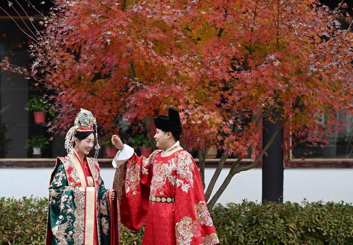NanhuMedia's tweet photo. On the evening of December 17, by the #Nanhu in downtown Jiaxing, vibrant #redmapleleaves 🍁 created a picturesque scene with a couple dressed in #traditionalattire 👰🤵.
In early #winter ❄️, the Nanhu is surrounded by fiery red maple leaves, attracting many residents and tourists daily for photos 📸 and check-ins.